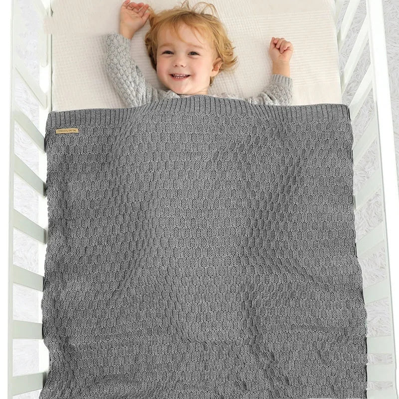 Solid colour acrylic infant blanket with textured lines in beige khaki, laid flat showing 70x90cm size.