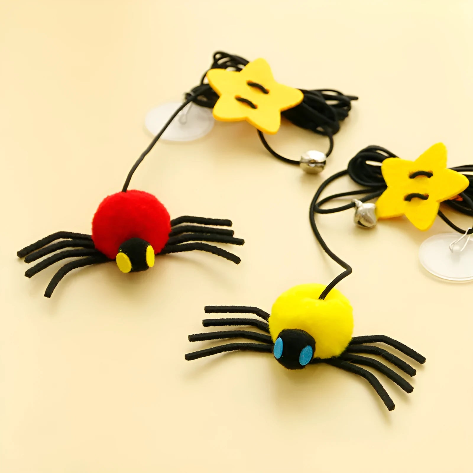Hanging door cat toy with elastic rope, feather, bell and spider attachments in red or yellow colour